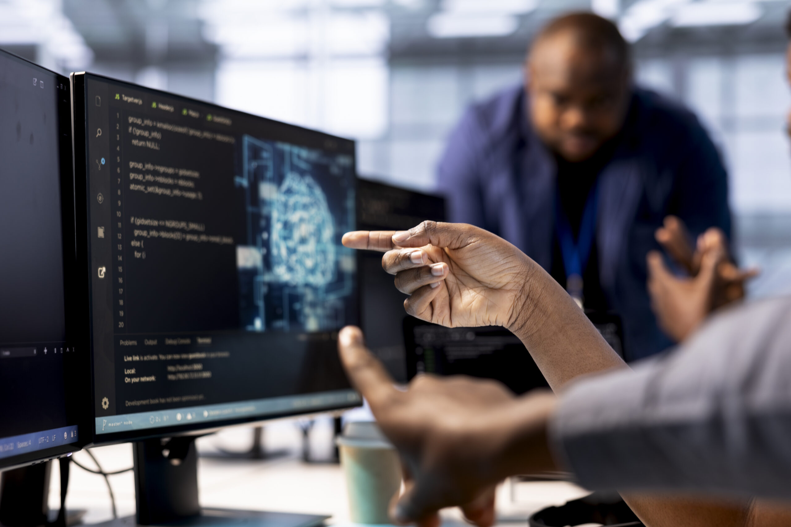 Server farm admin showing colleague AI technology on computer, creating and implementing algorithms. Close up of data center worker pointing finger to artificial intelligence tech on PC